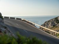 the road to the ocean along the cliffs by the ocean is empty and there are cars on both sides