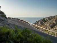 the road to the ocean along the cliffs by the ocean is empty and there are cars on both sides