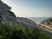 the road to the ocean along the cliffs by the ocean is empty and there are cars on both sides