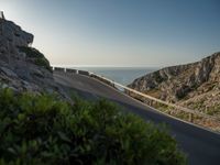 the road to the ocean along the cliffs by the ocean is empty and there are cars on both sides