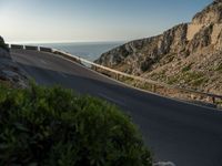 the road to the ocean along the cliffs by the ocean is empty and there are cars on both sides