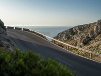 the road to the ocean along the cliffs by the ocean is empty and there are cars on both sides