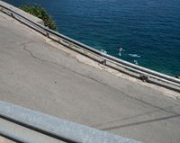 a paved road beside some large boats and a bridge with a bridge to the water