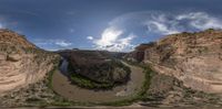 a panoramic photo of a wide river that runs between two rocky cliffs on top of a slope