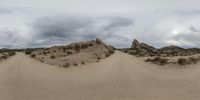 the dirt road is wide and it looks empty from all around the corner, as seen in a fisheye lens