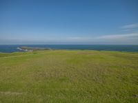 the grassy hill overlooks the ocean to the west of the island with one black dog