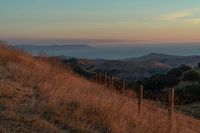 this is an image of a hilly countryside scene at sunset time in the western united states