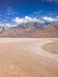 a desert area that is very brown with sand and mountains in the background, there is no one on it