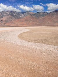 a desert area that is very brown with sand and mountains in the background, there is no one on it