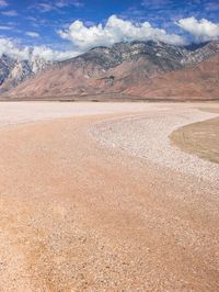 a desert area that is very brown with sand and mountains in the background, there is no one on it