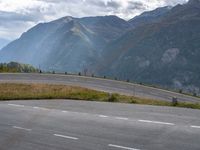 a man on an empty road near the mountains and a road sign with no cars