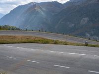 a man on an empty road near the mountains and a road sign with no cars