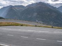 a man on an empty road near the mountains and a road sign with no cars