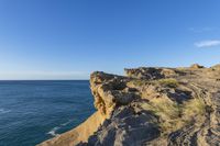 an image of the view from a cliff overlooking the ocean and sky in winter time