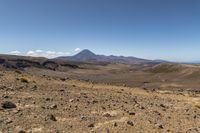 a barren area with rocks and rocks in front of mountains that are in the distance