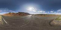 this photo was taken using an fish eye lens of a paved road in the desert