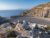 an image of a mountain road by the ocean in the afternoon light taken at dawn