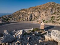 an image of a mountain road by the ocean in the afternoon light taken at dawn