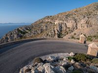 an image of a mountain road by the ocean in the afternoon light taken at dawn