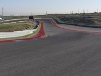 an empty track at a motorsports club with some red and white stripeing on it