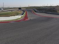 an empty track at a motorsports club with some red and white stripeing on it