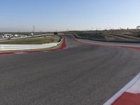 an empty track at a motorsports club with some red and white stripeing on it