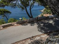 a motorcyclist riding on an empty paved road by the sea or a small island