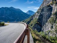 a highway with the mountains in the background with power lines on both sides and wires hanging over it