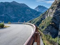 a highway with the mountains in the background with power lines on both sides and wires hanging over it