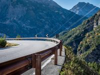 a highway with the mountains in the background with power lines on both sides and wires hanging over it