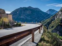 a highway with the mountains in the background with power lines on both sides and wires hanging over it