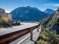 a highway with the mountains in the background with power lines on both sides and wires hanging over it