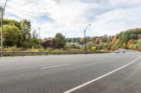 a highway with signs on both sides in front of an autumn landscape and a blue sky with white clouds