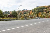 a highway with signs on both sides in front of an autumn landscape and a blue sky with white clouds