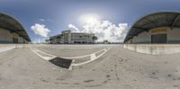 a fish eye view looking down at the ground from a highway and road side parking garage