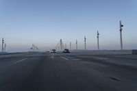 a highway with traffic on it and construction cranes in the background during the day and dusk