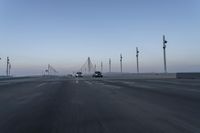 a highway with traffic on it and construction cranes in the background during the day and dusk