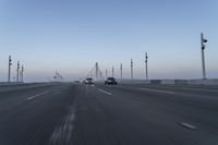 a highway with traffic on it and construction cranes in the background during the day and dusk