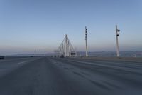 a highway with traffic on it and construction cranes in the background during the day and dusk