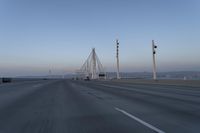 a highway with traffic on it and construction cranes in the background during the day and dusk