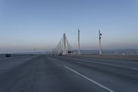 a highway with traffic on it and construction cranes in the background during the day and dusk