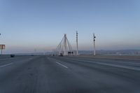 a highway with traffic on it and construction cranes in the background during the day and dusk