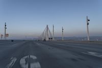 a highway with traffic on it and construction cranes in the background during the day and dusk