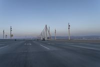 a highway with traffic on it and construction cranes in the background during the day and dusk