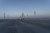 a highway with traffic on it and construction cranes in the background during the day and dusk