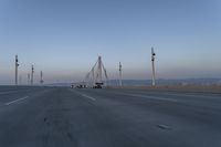 a highway with traffic on it and construction cranes in the background during the day and dusk