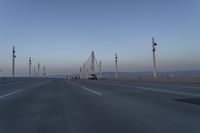 a highway with traffic on it and construction cranes in the background during the day and dusk