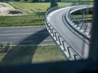 a view from a window of traffic on a highway with a bike path below them