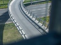 a view from a window of traffic on a highway with a bike path below them