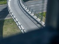 a view from a window of traffic on a highway with a bike path below them